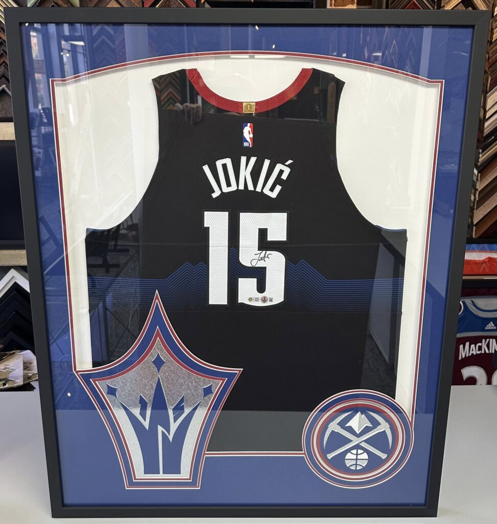 Custom framed Denver Nuggets Nikola Jokic jersey with team logos and sports memorabilia display